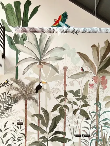 A close-up of the large-scale rainforest mural, showing the depth created by layering different shades of green and various types of foliage.