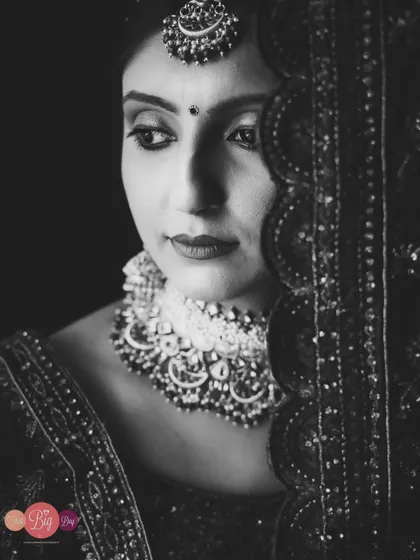 A classic, elegant black and white bridal portrait of Khushi, focusing on her expression and the intricate details of her attire.