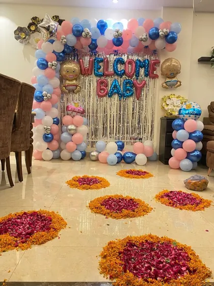 Another angle of the 'Welcome Baby' home decoration, showing the combination of modern balloon decor and traditional flower petal arrangements on the floor.