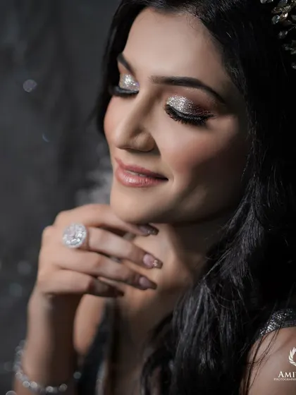 A close-up beauty shot of the bride, highlighting her sparkling eye makeup and the stunning diamond ring. This portrait is all about glamour and the fine details.