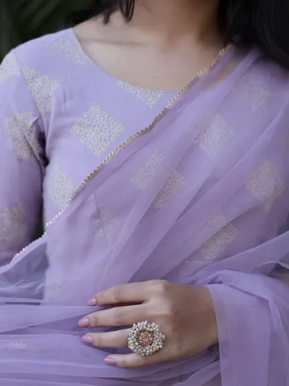 A close-up detail shot of the fabric, the dupatta, and the large floral ring, showcasing the complete styling of the look.