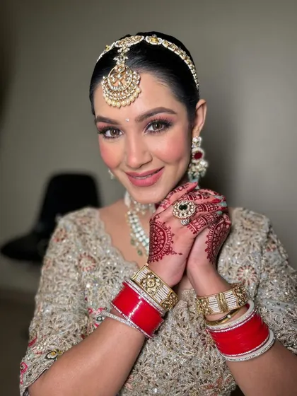 The joy of a bride, complete with her chooda (bridal bangles). The makeup is designed to last through all the ceremonies and celebrations, keeping her looking fresh and beautiful.