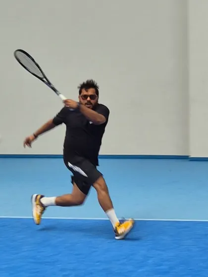 Executing a powerful forehand during a match in Poland. As a coach, I believe in leading by example and staying active in the sport.