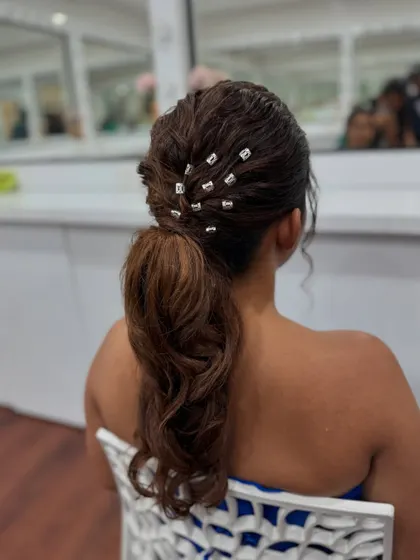 The reflection in the mirror shows another angle of this chic and contemporary ponytail hairstyle.