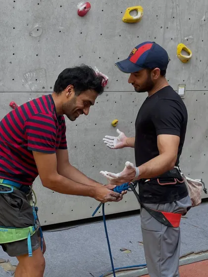 An instructor demonstrates the proper way to tie into the rope for lead climbing. Mastering these fundamental safety skills is crucial before you start climbing.