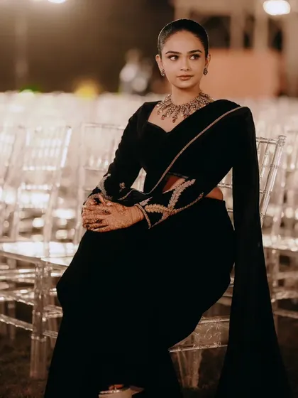 A client looking absolutely chic in a custom all-black velvet lehenga saree. The full-sleeve blouse and matching draped skirt create a sophisticated and modern silhouette.