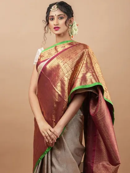 A model in a traditional Kanjivaram saree wears a maang tikka and statement earrings for a complete bridal or festive look.