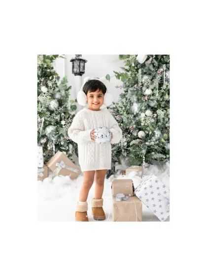 Holding a snowball in our winter wonderland studio setup. I love creating these immersive scenes for my Christmas mini sessions to make them extra special.