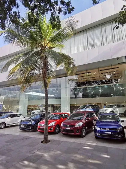 The exterior of a transformed Maruti Suzuki Arena showroom in Bangalore. The design features a modern glass facade that maximizes visibility into the showroom, creating a strong street presence and inviting customers inside.
