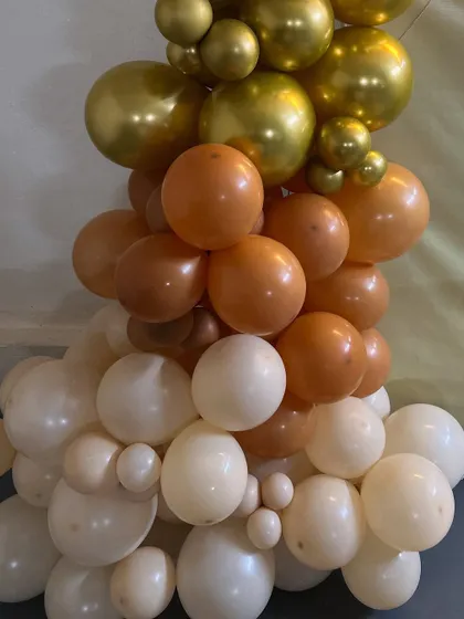 We use a variety of balloon sizes and colors to create rich, textured garlands. This close-up shows the beautiful blend of cream, orange, and gold balloons for a 30th birthday party.