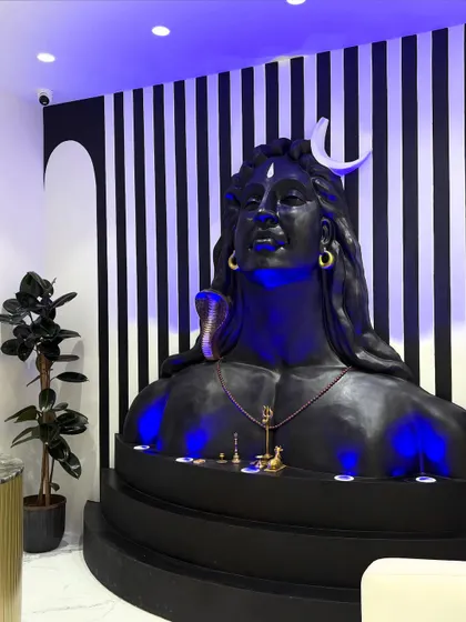 A side view of the completed Adiyogi installation, showing how it integrates with the reception area. The lighting creates a divine aura, making the space feel both welcoming and reverent.