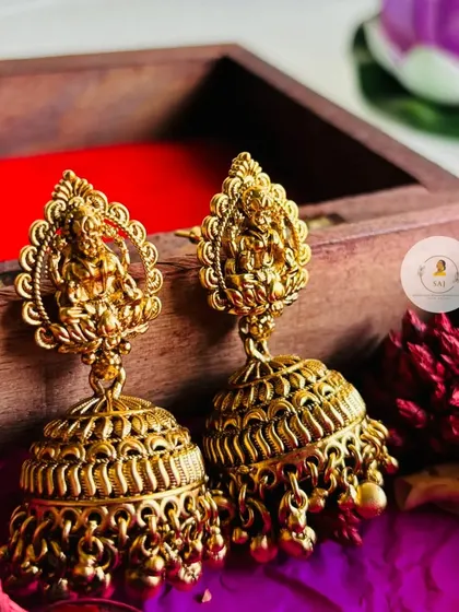 Introducing our exquisite temple jewellery jhumkas. These earrings feature a detailed Goddess Lakshmi stud with a large, intricately carved jhumka base.