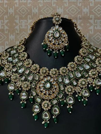 This green Kundan bridal necklace set is a statement piece for any bride. The combination of large Kundan stones and delicate green beads gives it a royal look, perfect for pairing with a traditional lehenga or saree.