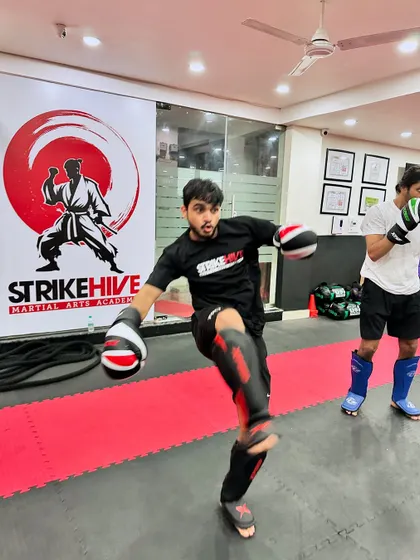 A student practices a front kick during a drill. This dynamic shot captures the energy and movement that make our classes an exciting alternative to traditional gym workouts.