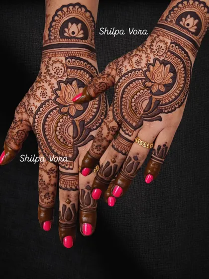 A bold, modern design with a large central lotus motif and intricate patterns on the fingers.
