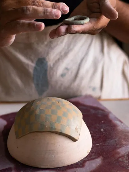 A student forming a piece from a patterned Nerikomi slab. This technique creates stunning, integrated designs that run through the entire clay body.