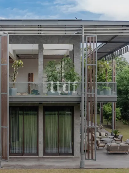 We designed this modern home to breathe with its natural surroundings. The structure uses raw concrete, warm wood, and expansive glass to dissolve the boundaries between the interior and the lush greenery outside, creating a seamless indoor-outdoor living experience.