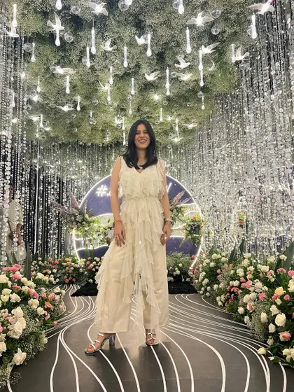 Finding the perfect photo spot at a sangeet. This white ruffled jumpsuit was a fantastic choice for the evening, combining the elegance of a dress with the comfort of pants.
