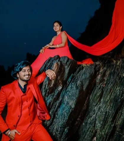A dramatic pre-wedding shoot on the rocks. The matching red outfits for the couple create a bold and coordinated look that is perfect for making a statement.