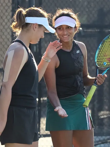 Sahaja and her doubles partner strategizing between points, an essential part of doubles play that we emphasize in our training.