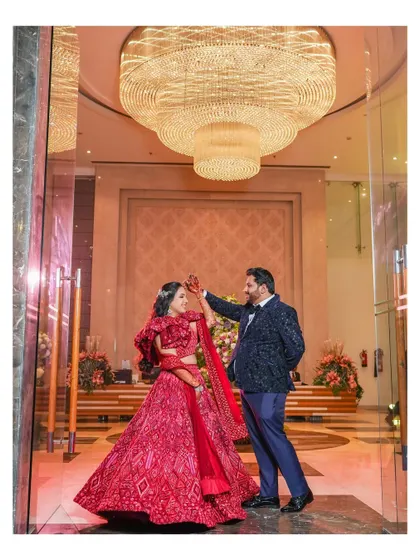 A grand portrait of the couple dancing under a massive crystal chandelier. This shot combines the elegance of the venue with the couple's joyful celebration.