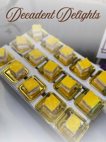 Our 'Decadent Delights' include a variety of bite-sized Indian sweets. This tray of layered barfis showcases our ability to create traditional mithai with a modern, elegant presentation.