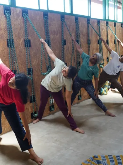 In our Kurunta workshop, students learn to use the ropes to assist with standing poses like Trikonasana, helping to refine alignment and deepen the stretch.