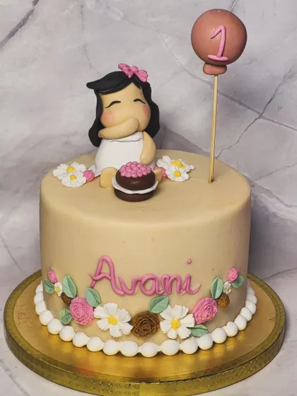 A super cute cake for a baby girl's first birthday. It features a hand-sculpted fondant figure of the birthday girl and delicate floral details.