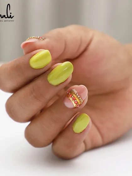 A full hand view of the lime green nails with a custom red and gold crystal accent band. A vibrant and unique look.