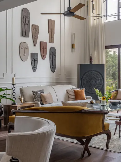 We layered the living room with antiques and collectibles from our client's personal collection, including a striking gallery of masks. This approach ensures the home truly tells the story of the people who live there.