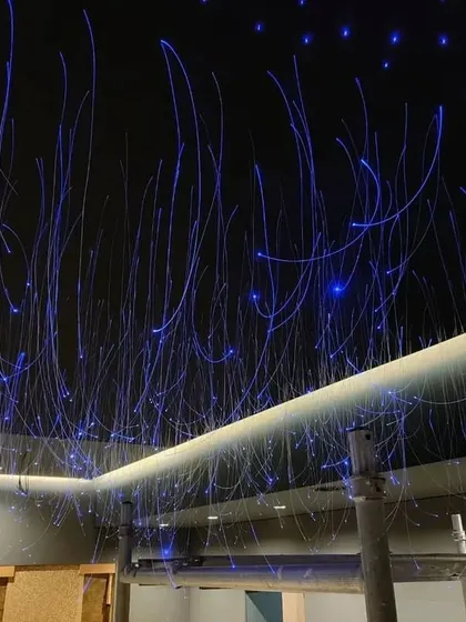 Installing a fiber-optic star ceiling is a meticulous process. Here you can see the individual fibers being threaded through the ceiling panel before they are cut to size.