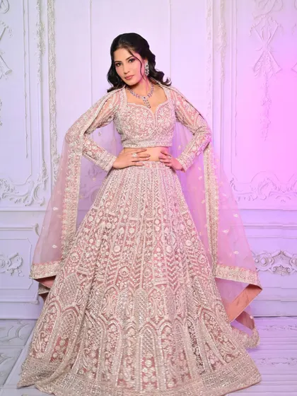 A full-length shot of the pastel pink lehenga, demonstrating a complete and polished look for a modern bride.