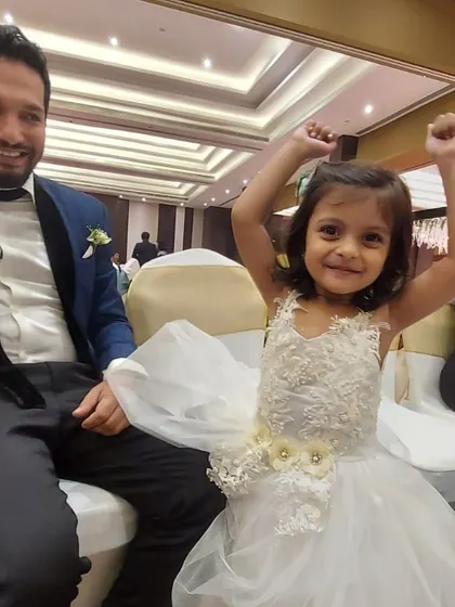 The pure joy of a party. This little girl is having the time of her life in her custom white tulle dress with beautiful floral appliqué details.