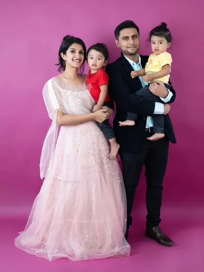 This full-length family portrait against a vibrant pink backdrop is modern and fun. We offer a variety of solid color backdrops for a clean, studio look.