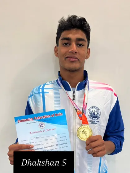 Dhakshan S holding his gold medal and certificate of honor.