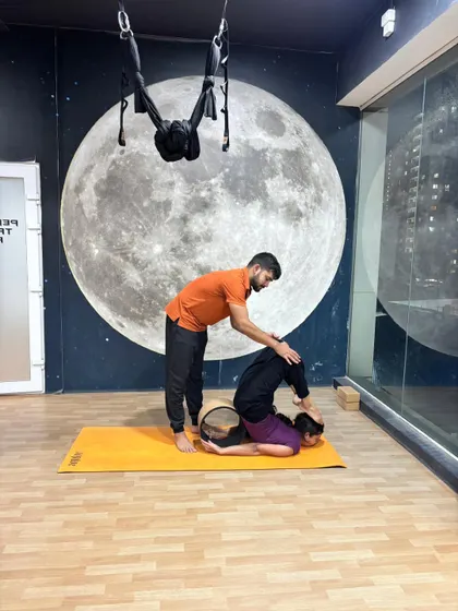 The yoga wheel is a fantastic tool for opening the back. Here, I'm helping a student use the wheel to safely deepen her backbend and release tension in the spine.