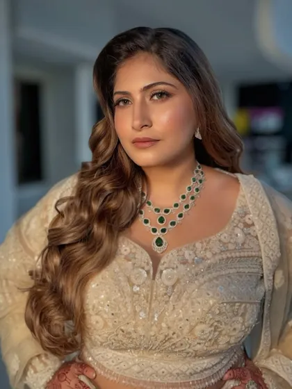 A stunning reception look with dramatic green smokey eyes and voluminous curls, paired with a magnificent emerald necklace.