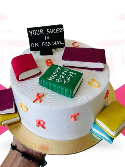 A unique, book-themed cake designed for a student. This 1-pound chocolate cake is decorated with fondant books and a motivational message, making it a thoughtful way to celebrate a birthday or academic achievement.