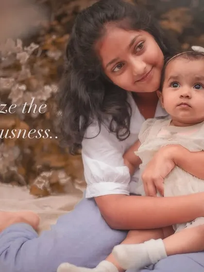 "Freeze the preciousness." A quiet, loving portrait of an older sister holding her baby sibling, a timeless memory of when they were this little.