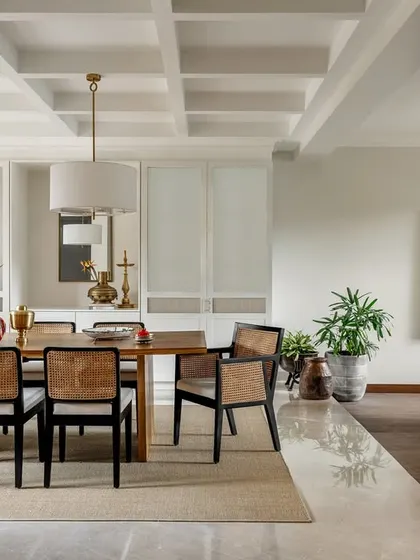 The dining room features a beautiful coffered ceiling and a wall of custom cabinetry for storage. The open connection to the living area makes it perfect for entertaining, maintaining a serene and stately presence.