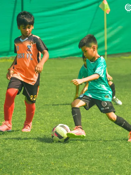 A U-9 player dribbles the ball with focus and control.