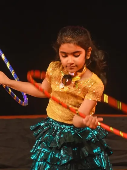 A close-up capturing the focus and determination of a young hoop dancer during her performance.