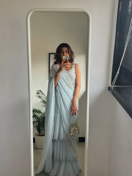 A mirror selfie showing off a powder blue ruffled saree. This is a modern and trendy take on the classic nine yards.