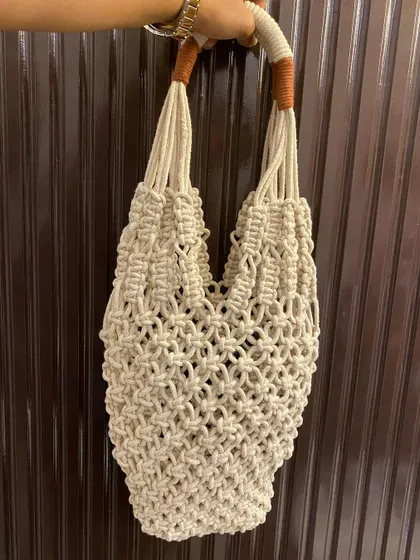 This is my full macrame net-style tote bag, a perfect companion for a trip to the market. It's lightweight, expandable, and has sturdy, comfortable handles.