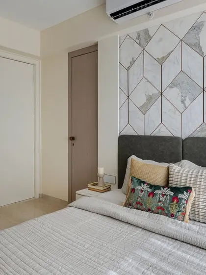 A different angle of the guest bedroom, showing the geometric marble bed back and the two-toned wardrobe that adds a modern touch.