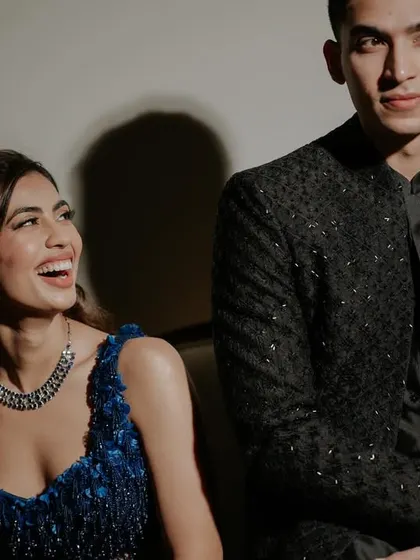A candid, happy moment between the couple. Her makeup looks flawless even while sharing a laugh.