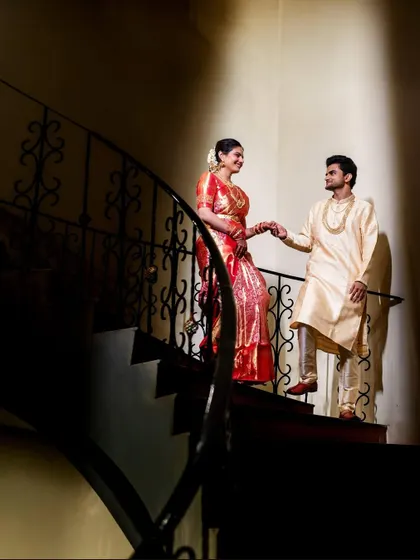 A beautifully composed shot of the couple on a spiral staircase. The dramatic lighting and elegant pose create a sophisticated and artistic wedding portrait.