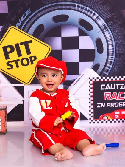 Our future racing champion is ready for the track. The "Race in Progress" sign and other props add to the excitement of the shoot.