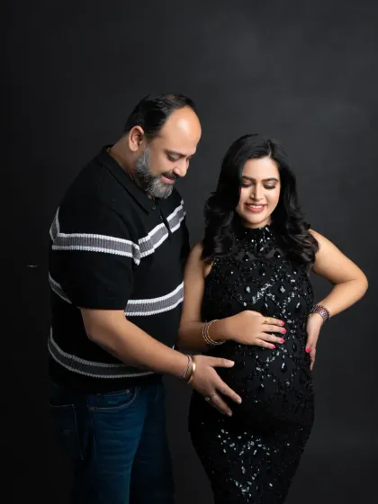 A happy and relaxed moment between the parents-to-be. Their smiles are infectious in this classic portrait, dressed in elegant black attire.
