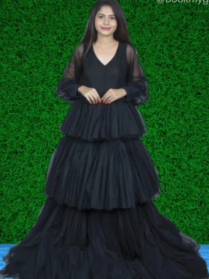 For a touch of modern elegance, this black tiered net gown is a perfect choice. Its sheer long sleeves and layered skirt offer a chic and sophisticated silhouette for any event.